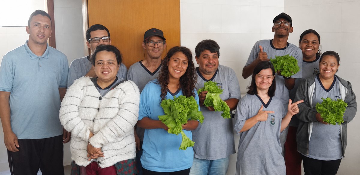 Equipe e atendidos da APAE comemorando a colheita da horta